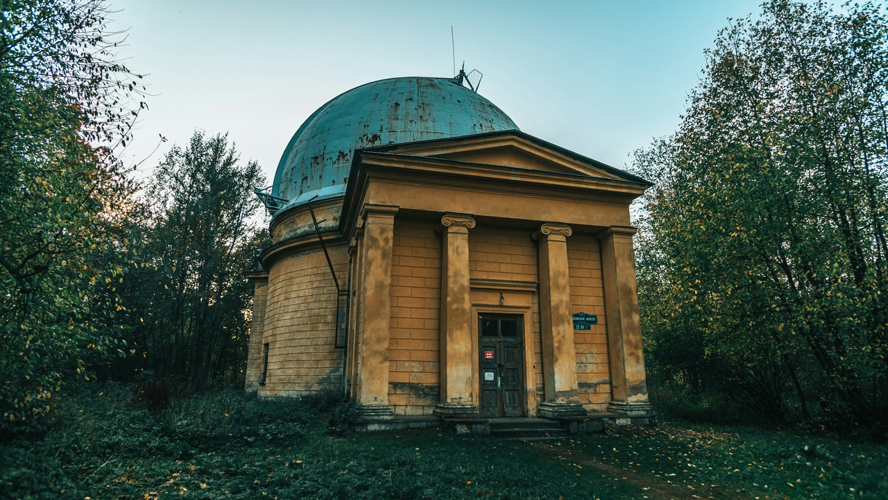 A modest backyard telescope and a pair of binoculars set up under a starry sky.