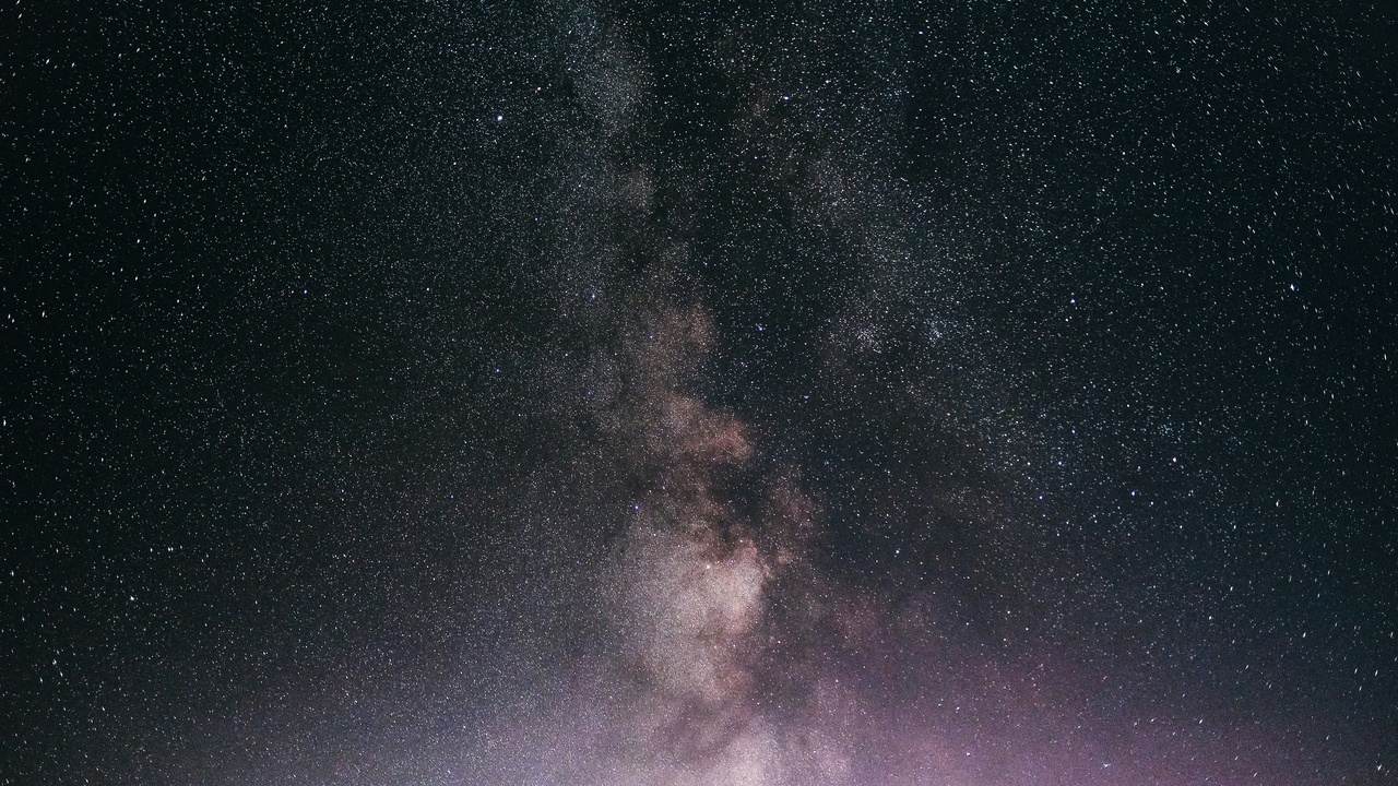 A smartphone displaying a star map app under a night sky.