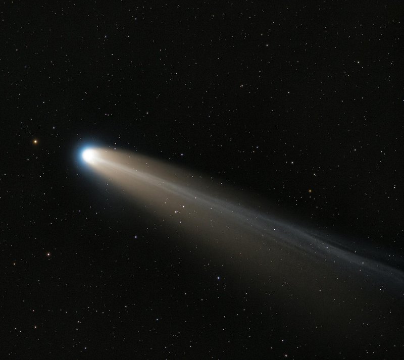 A bright comet streaks through the star-filled night sky, emitting a glowing tail.