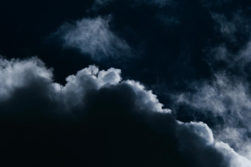 Moody dark clouds forming in a night sky, evoking mystery and depth.