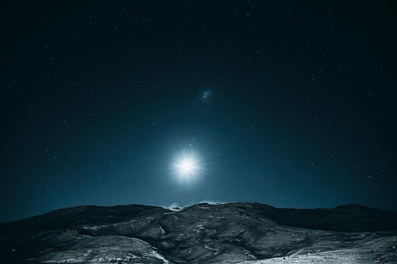 A breathtaking view of a moonlit night sky filled with stars over a serene landscape.