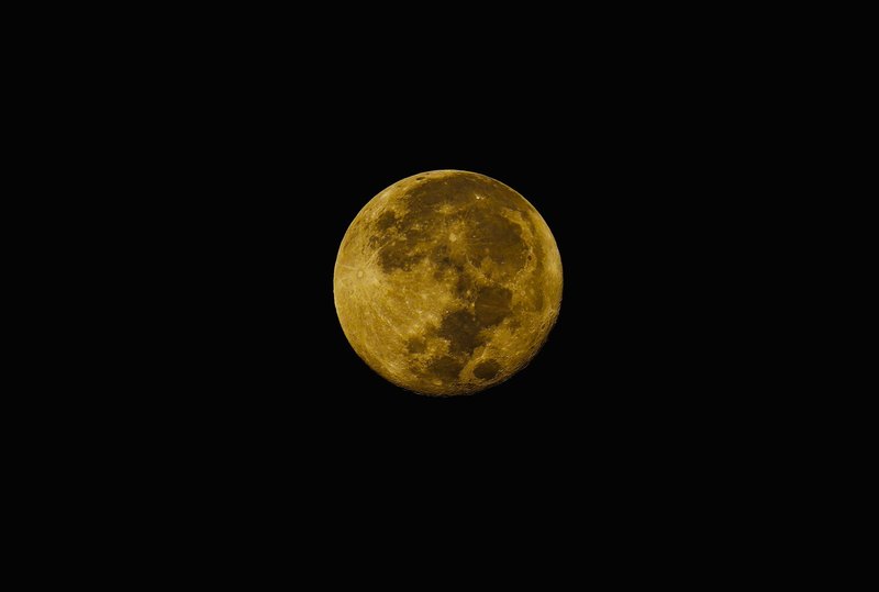 Crisp photo of a full moon with visible craters set against a clear black night sky.