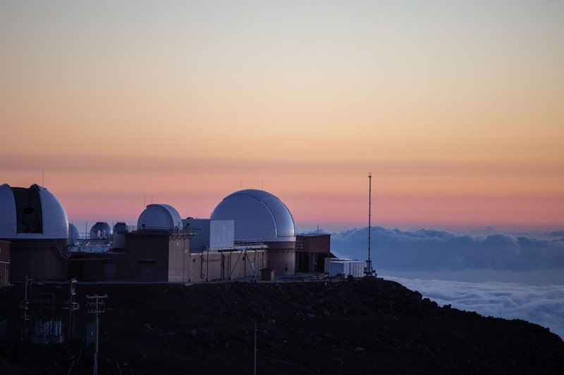 Observatory domes against a vibrant sunset sky, capturing astronomical beauty.