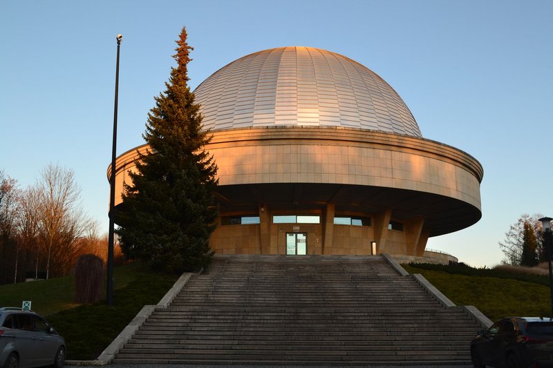 Exterior view of the Silesian Planetarium in Chorzów at sunset with a clear sky.