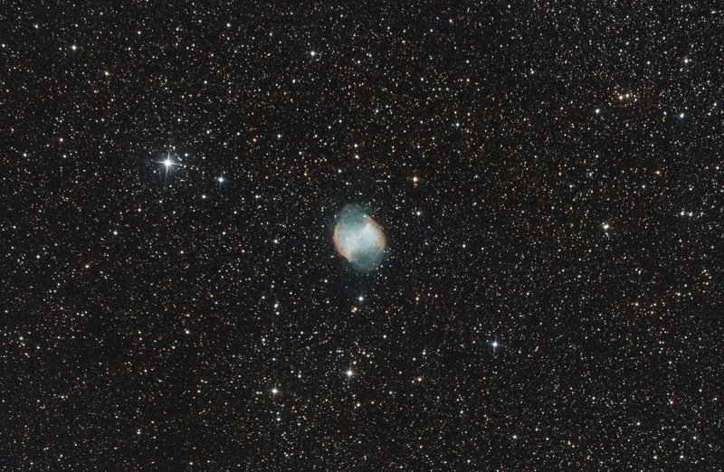 A stunning view of the M27 Dumbbell Nebula surrounded by countless stars in the night sky.