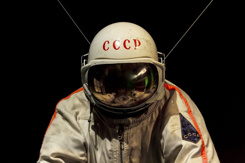 Close-up of a classic Soviet-era cosmonaut suit in a dark exhibit setting.