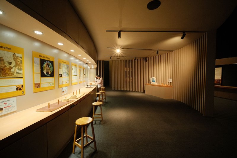 Quiet museum interior featuring educational displays and stools under warm lighting.